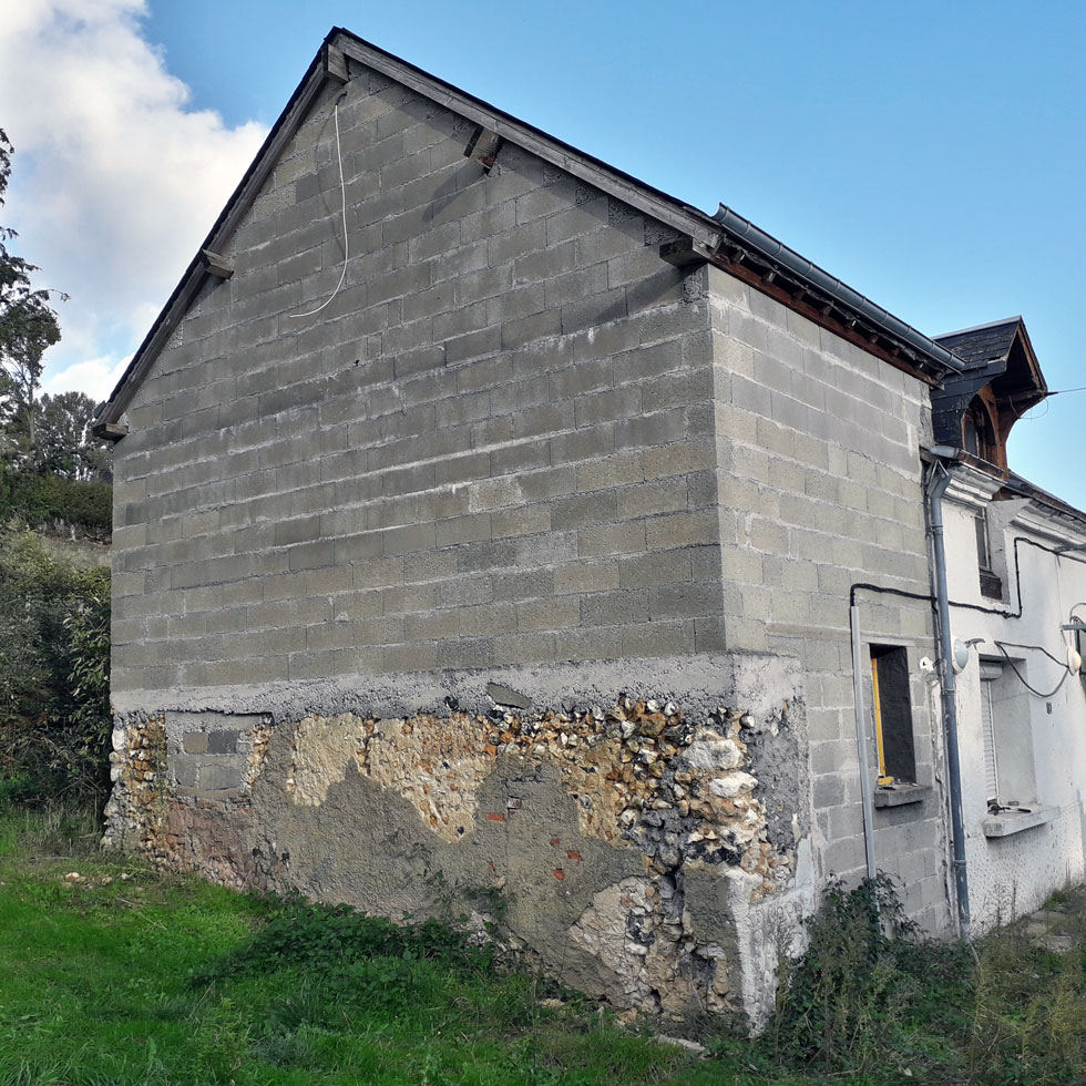 Pignon en parpaings nu et moellons.
