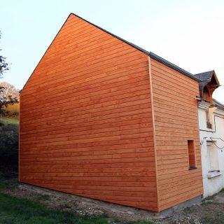 Pignon recouvert d'un bardage en bois de pin douglas.