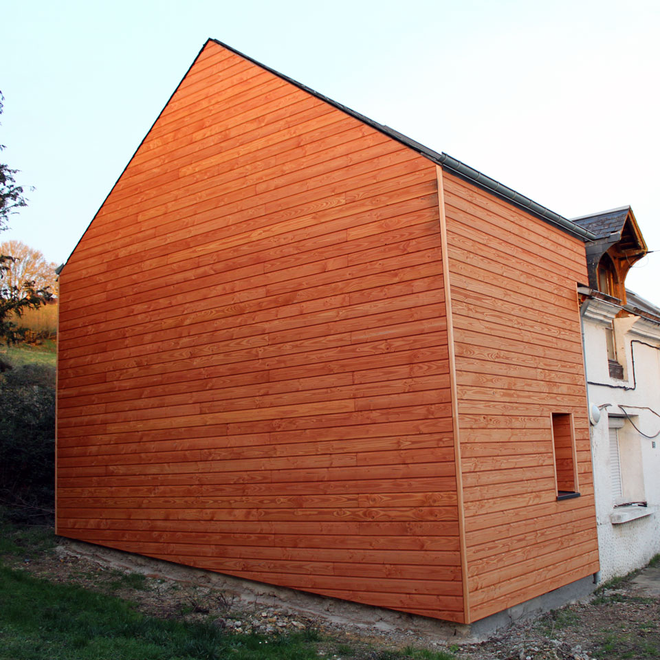 Pignon recouvert d'un bardage en bois de pin douglas.