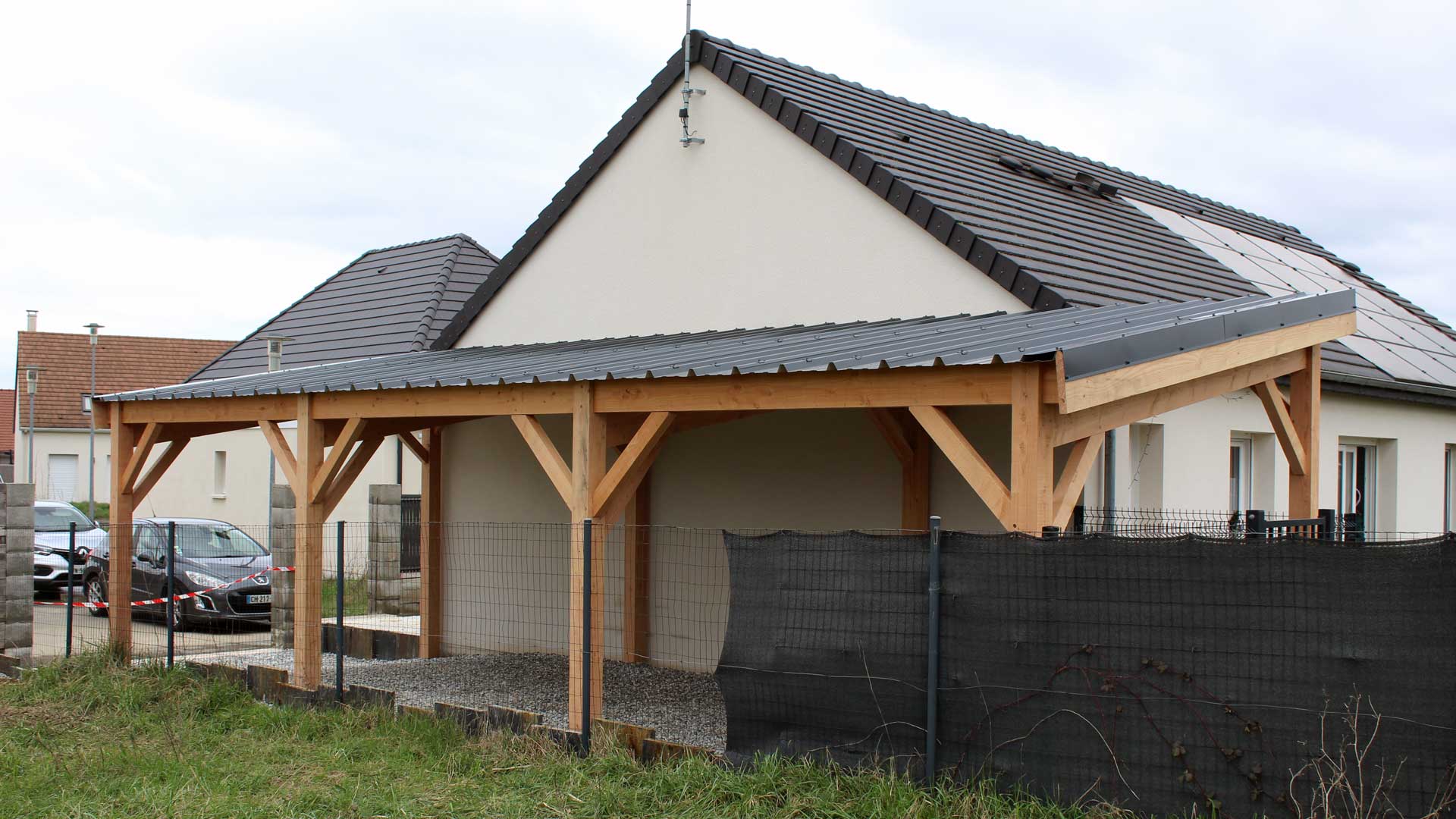 Carport bois 2 voitures couvert en bac acier vu de côté.