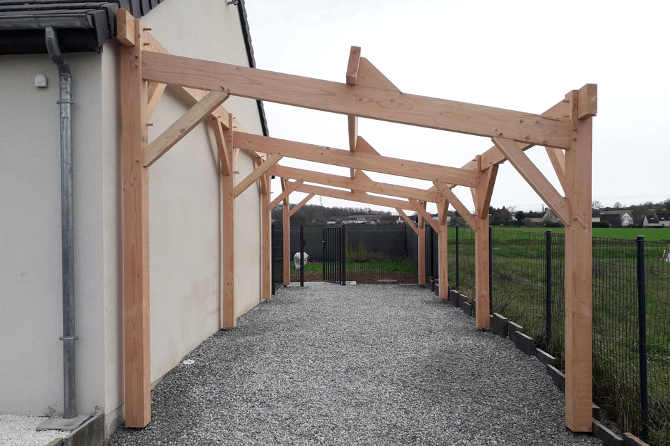 Carport bois en charpente traditionnelle vu de face.
