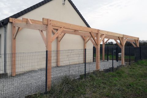 Carport bois en charpente traditionnelle vu de côté.