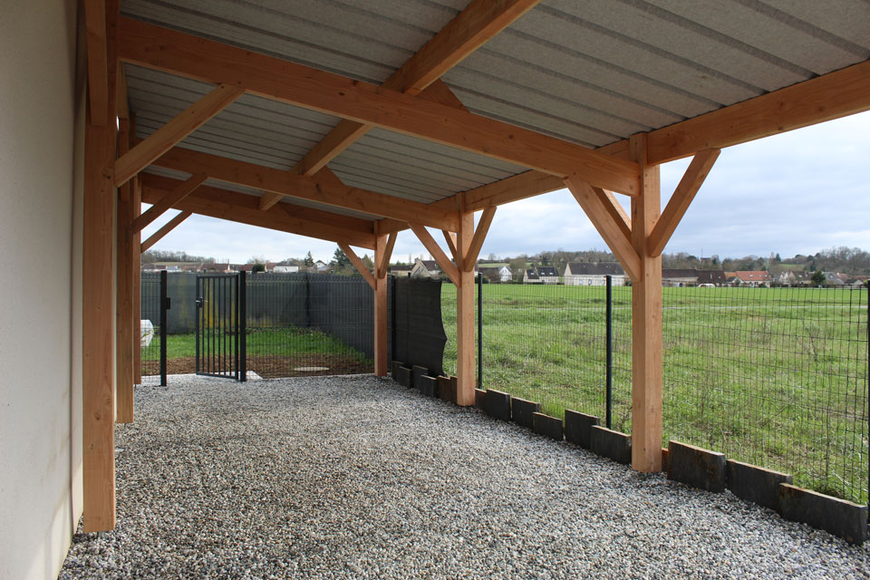 Vue du dessous d'un carport bois en charpente traditionnelle.